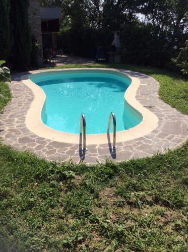 a swimming pool with two metal rails in a yard at B&B Villa Rossana in Langhirano