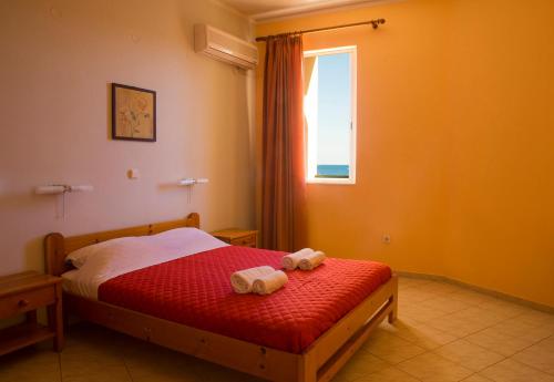 a bedroom with a bed with two teddy bears on it at Sunrise Hotel in Agia Ermioni
