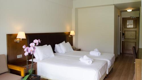a hotel room with a bed with towels on it at Rodon Hotel and Resort in Agros