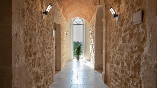an empty hallway with a stone wall and a potted plant at L'hôtel du Couvent in Vagnas
