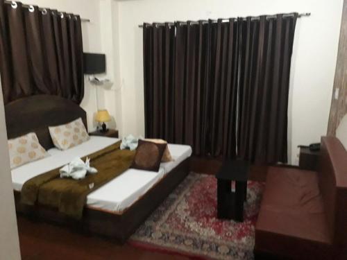 a bedroom with a bed and a black curtain at Trimurti Pine Valley Resort in Shimla