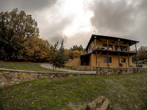 a large yellow house with a stone wall at Agramada in Arnaia