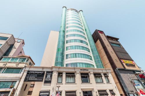 a tall building in front of two other buildings at Gangneung Tourist Hotel in Gangneung