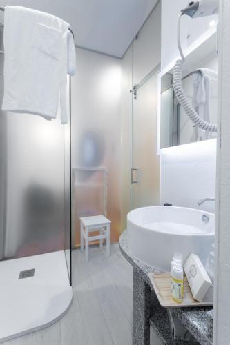 a bathroom with a sink and a bath tub at Quinta da Magnólia AR in Urzelina