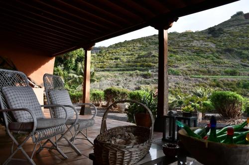 a patio with chairs and a table with a view of a mountain at Haciendas del Valle - Casa San Miguel in Valle de Guerra