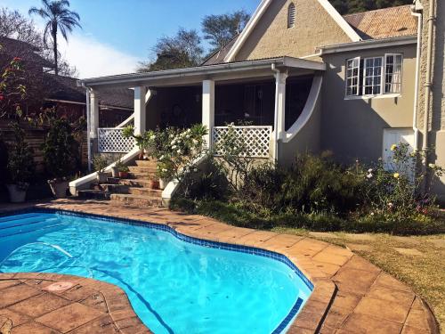 a swimming pool in front of a house at Tancredi B&B in Pietermaritzburg