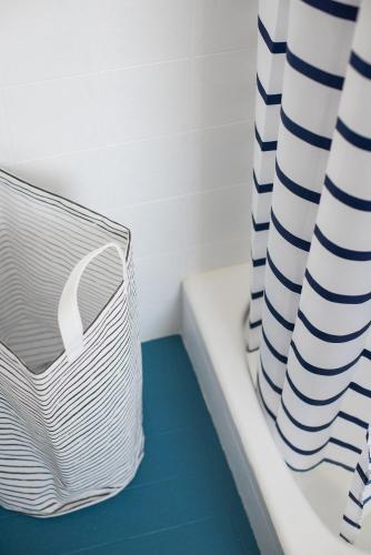 a white basket sitting on a bath tub next to a curtain at Central, spacious, great view in Hvar