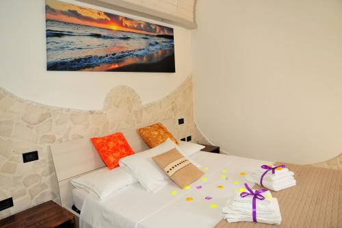 a bedroom with a white bed with colorful pillows at Tenuta Paifer in Otranto