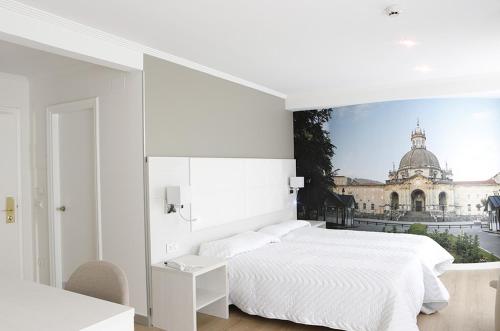 um quarto com uma cama branca e vista para um edifício em Hotel Loiola em Azpeitia