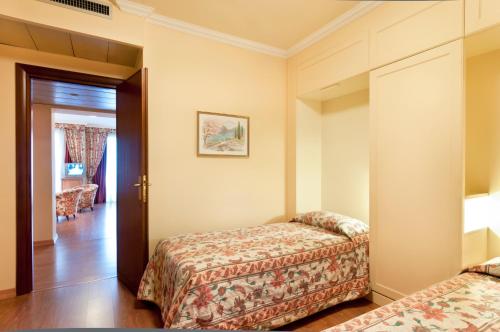 a hotel room with two beds and a door at Residence Carl&Do in Baveno