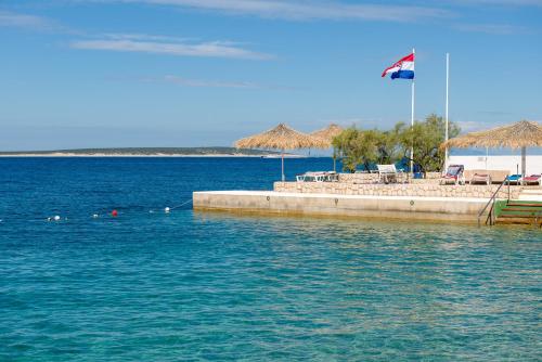 a beach with a flag and a pier with water at Holiday Park Mandrice in Mandre