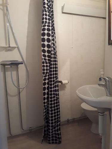 a bathroom with a shower curtain next to a sink at Älgbergets Bed & Breakfast in Ucklum