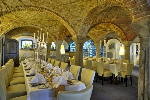 a dining room with white tables and yellow chairs at Hotel Gut Schmelmerhof in Sankt Englmar