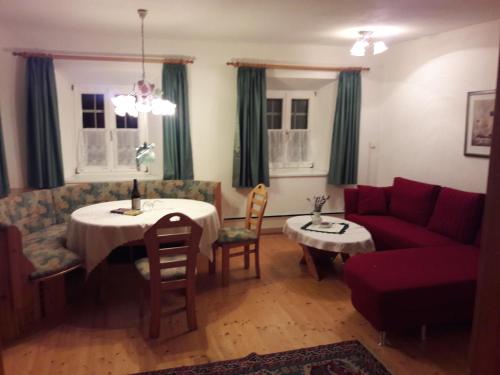 a living room with a table and a red couch at Ferienhaus im Thermenland (Loipersdorf, Blumau) in Ilz