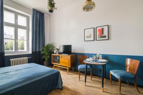 een slaapkamer met een bed en een tafel en stoelen bij Aparthotel Nowy Świat 28 in Warschau