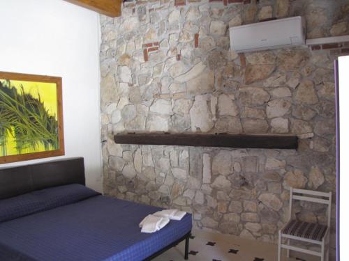 a bedroom with a stone wall and a bed at Mafrolla Carlo in Vieste