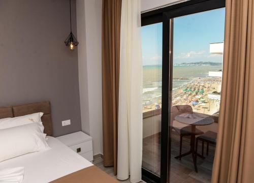 a bedroom with a bed and a view of the beach at Brilliant Hotel & SPA in Golem