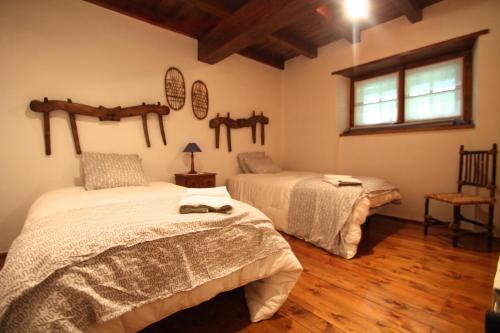 1 dormitorio con 2 camas y ventana en Pleta Aldosa, Casa rustica con chimenea y jardin, Zona Vallnord, en La Massana