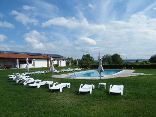 a group of white lawn chairs and a pool at Rumika Ecocenter in Elkhovo