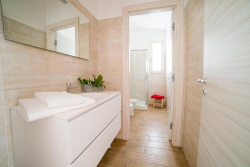 a bathroom with a white sink and a mirror at I Ruscioli in Torre Chianca
