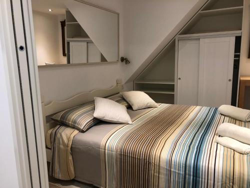 a bedroom with a bed and a staircase with a mirror at Apartment Susanj in Mošćenice