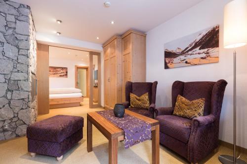 a living room with two chairs and a table at Alpenhotel Ischglerhof in Ischgl