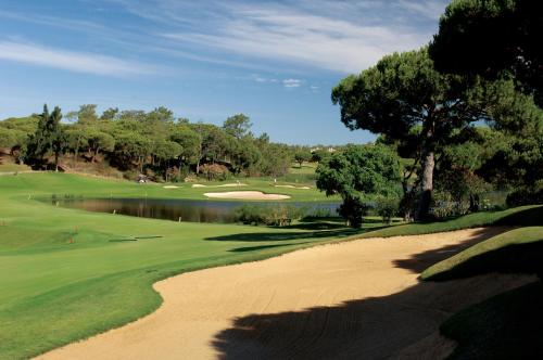 a view of a golf course with a pond and a green at Dona Filipa Hotel in Vale do Lobo