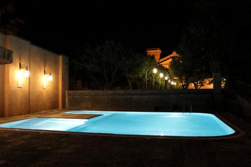 uma piscina à noite com luzes na parede em Castello di Casapozzano em Aversa