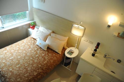 a bedroom with a bed and a lamp and a sink at Great Family Hotel in Taipei