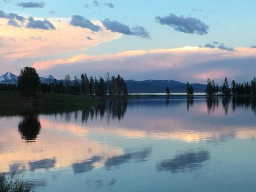 a view of a lake at sunset with trees and clouds at Yellowstone House of the Three Bears 2 Blocks to Downtown in Cody