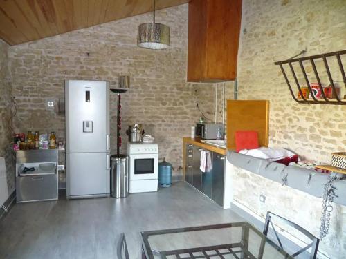 une cuisine avec un réfrigérateur blanc dans une pièce dans l'établissement Le Haut Fontaine : gîte 4/5 pers. ou site entier 9 pers, à Saint-Georges-lès-Baillargeaux
