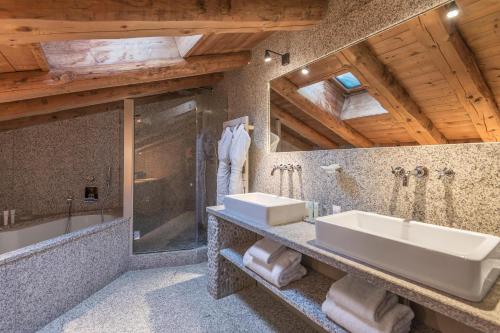 梅傑夫的住宿－瑪麗菲爾姆酒店，浴室配有2个盥洗盆、淋浴和浴缸。