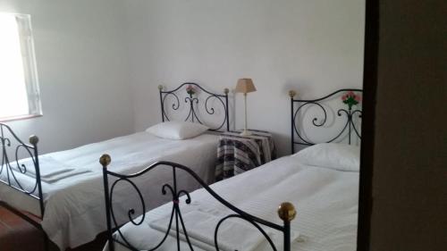 two beds in a bedroom with white walls at Quinta da Nora Velha in Mato de Miranda