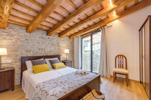um quarto com uma cama e uma grande janela em Flateli Diana em Sant Jordi Desvalls