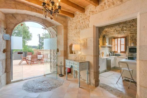 a kitchen with an archway and a dining room with a table at Flateli Diana in Sant Jordi Desvalls