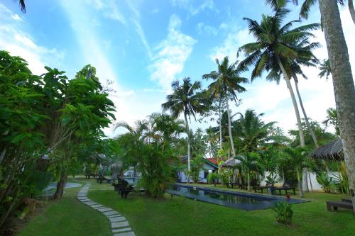 a park with palm trees and a swimming pool at Turtle Eco Beach in Matara