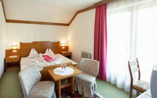 ein Hotelzimmer mit einem Bett, einem Tisch und Stühlen in der Unterkunft Frühstückspension Steffi in Sankt Kanzian am Klopeiner See