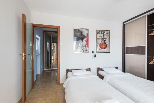 een rij van vier bedden in een kamer bij Samba Apartment in Wrocław