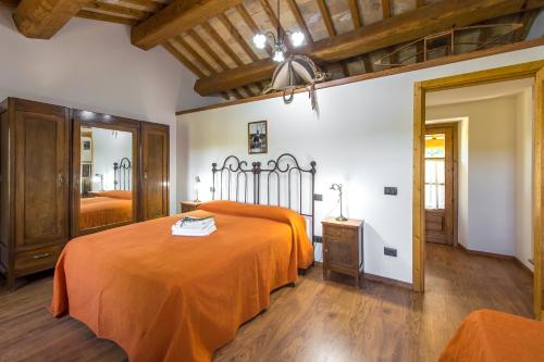 a bedroom with a bed with an orange bedspread at Fattoria Capobianco in Montefiascone