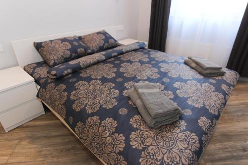 a bedroom with a bed with a blue and gold bedspread at Marbella Rezidence in Ventspils