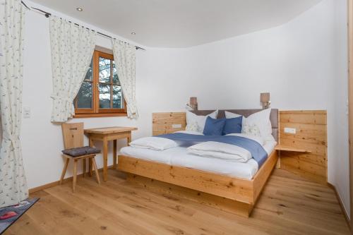 een slaapkamer met een houten bed met blauwe kussens bij Family Retreat Maria Alm in Maria Alm am Steinernen Meer