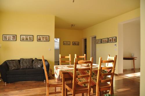 - une salle à manger avec une table, des chaises et un canapé dans l'établissement Bokros Vendégház, à Tordas