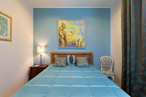 een blauwe slaapkamer met een bed en een stoel bij Luxurious Pink House and Parking in Porto