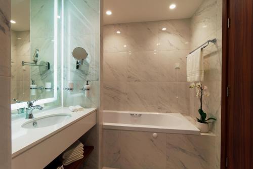 bagno con vasca, lavandino e doccia di Astor Garden Hotel a Sveti Konstantin i Elena