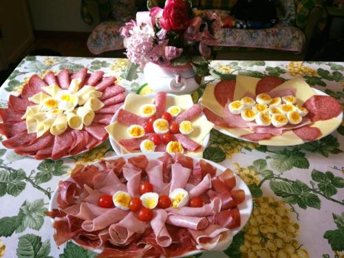 a table topped with plates of meats and cheese at Hotel 2000 in Fabriano
