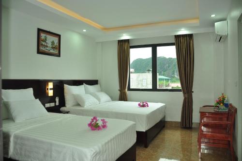 a hotel room with two beds and a window at Tam Coc Victoria Hotel in Ninh Binh