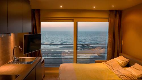 a room with a bed and a view of the ocean at middelkerke - frontaal zeezicht in Middelkerke