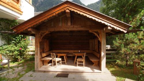 a wooden gazebo with a table and chairs in it at Hotel Garni Obermair in Mayrhofen