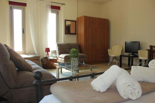 una sala de estar con un sofá y una mesa en Kerynia Apartments, en Pafos