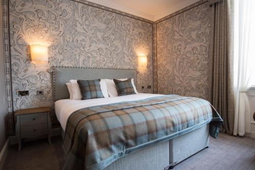 a bedroom with a bed in a room with wallpaper at The Beverley Arms Hotel in Beverley